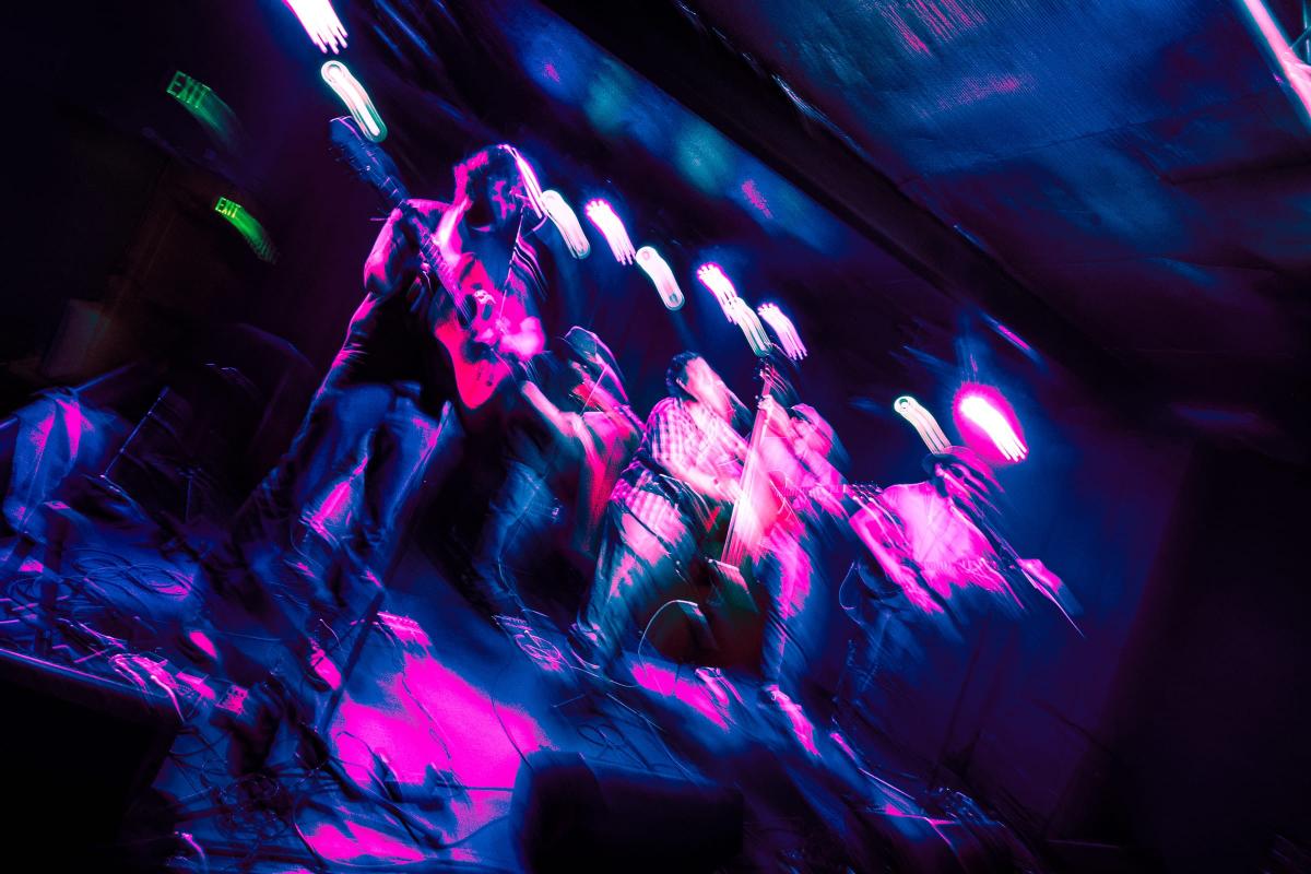 Blurry and colorful pic of the band performing live at Moe's. — © Jess Nelson